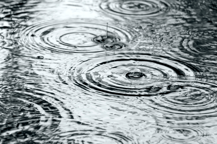 ThinkstockPhotos-185866732 Raindrops creating ripples on the surface of water in black and white.